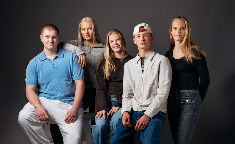 Seks elever ser i kamera. Inne.