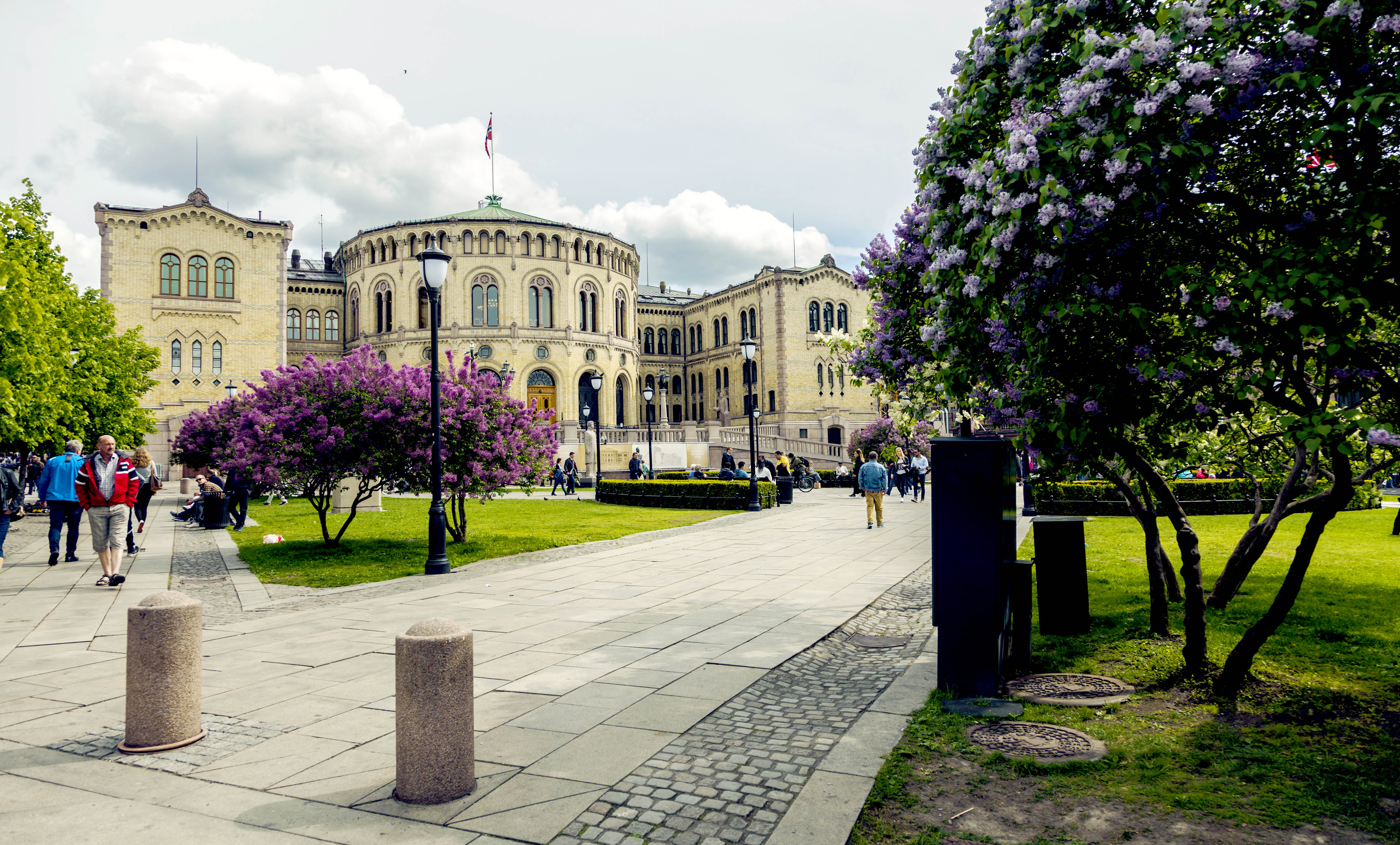 Fotografi av Stortingets eksteriør med folk som går