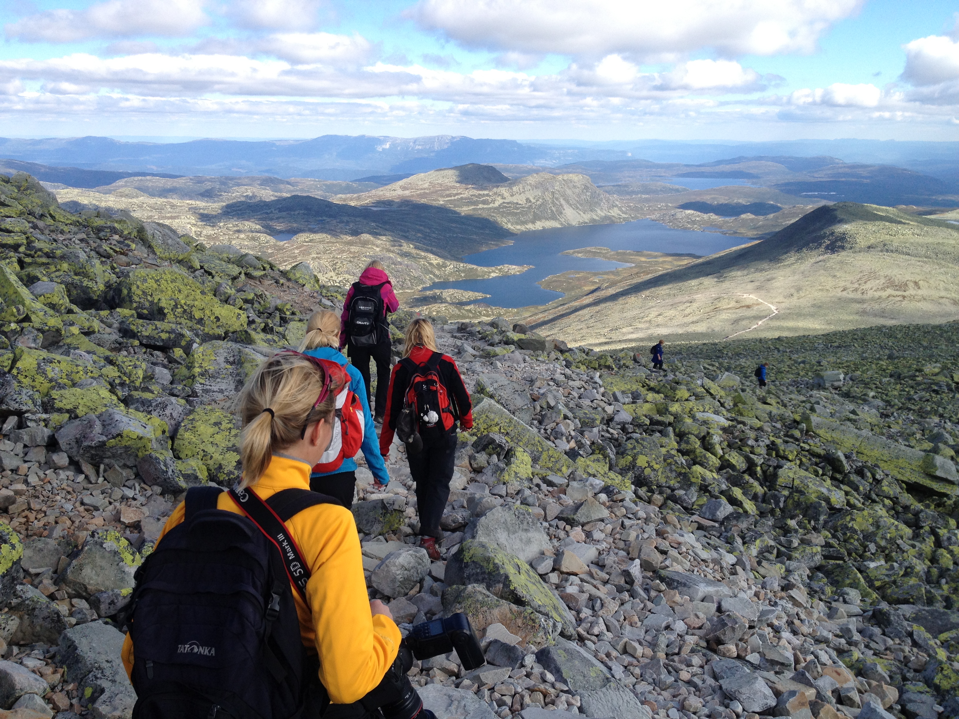 Bilde av turgåere med sekk som er på veg ned fra Gaustadtoppen
