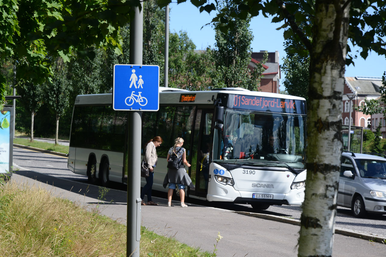 Busspassasjerer går på VKT-buss på busstopp