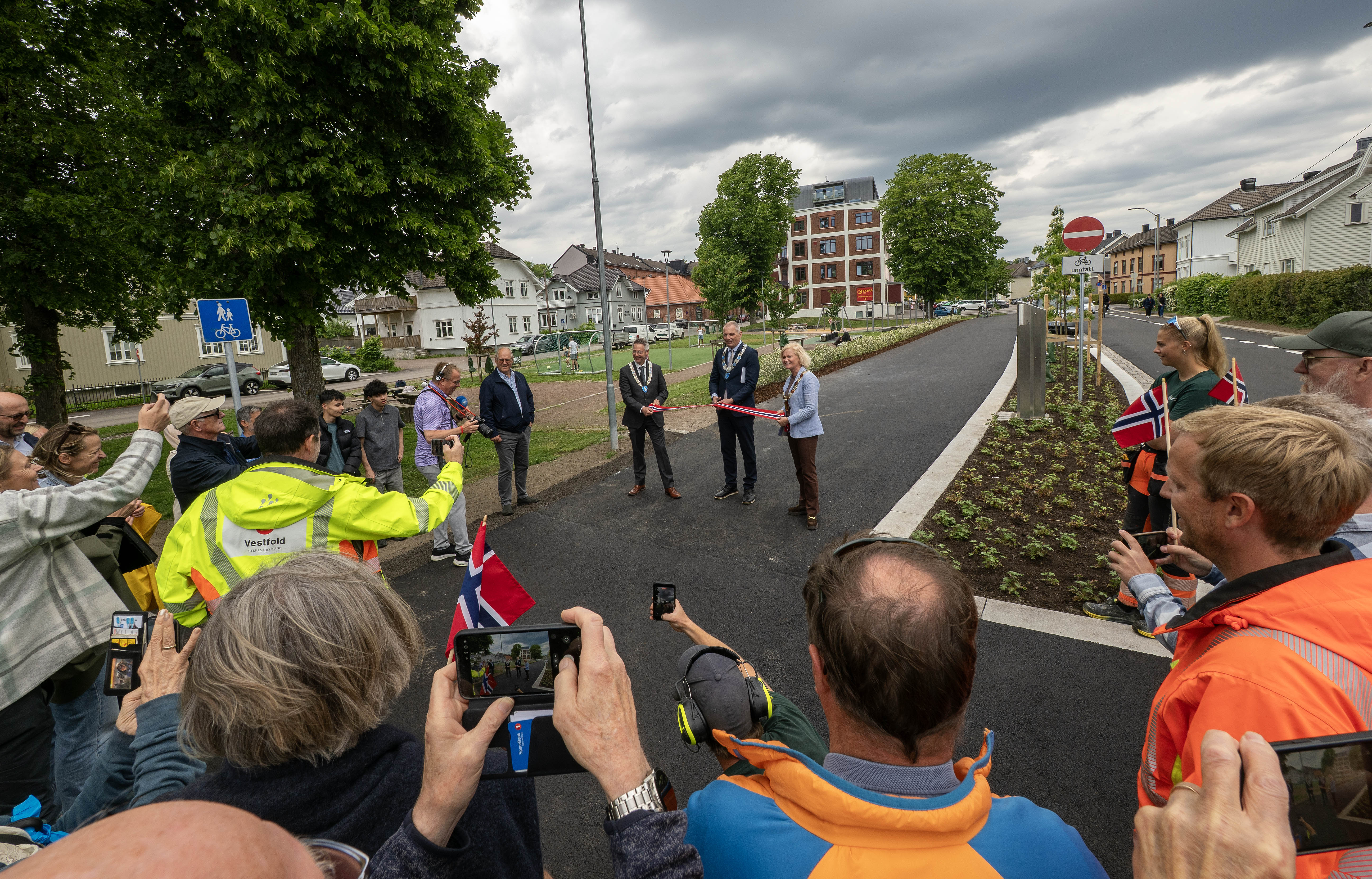 Foto av mange mennesker som ser på ordførere klippe snor under åpningen av Vestfoldgaten i Tønsberg
