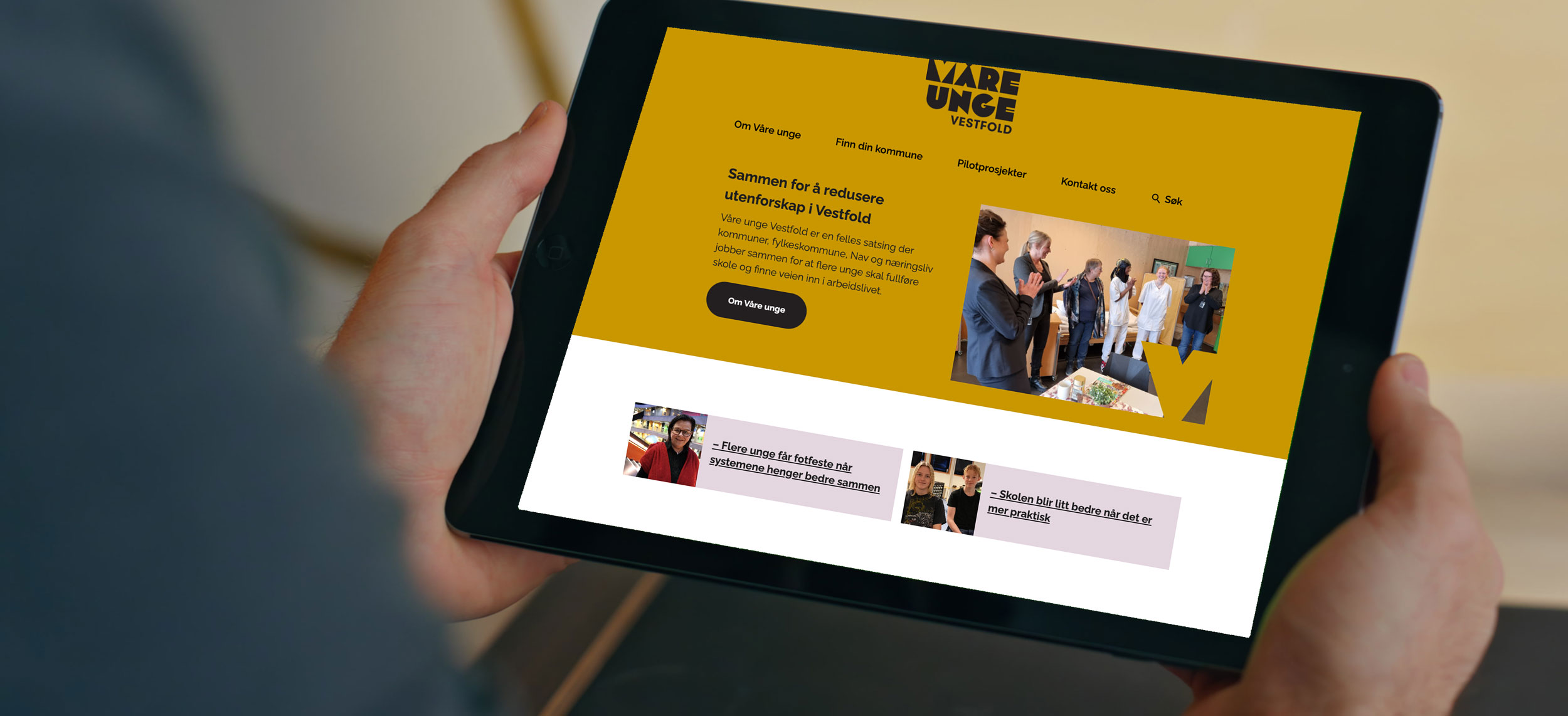Person holder nettbrett med Våre unge-nettsiden synlig