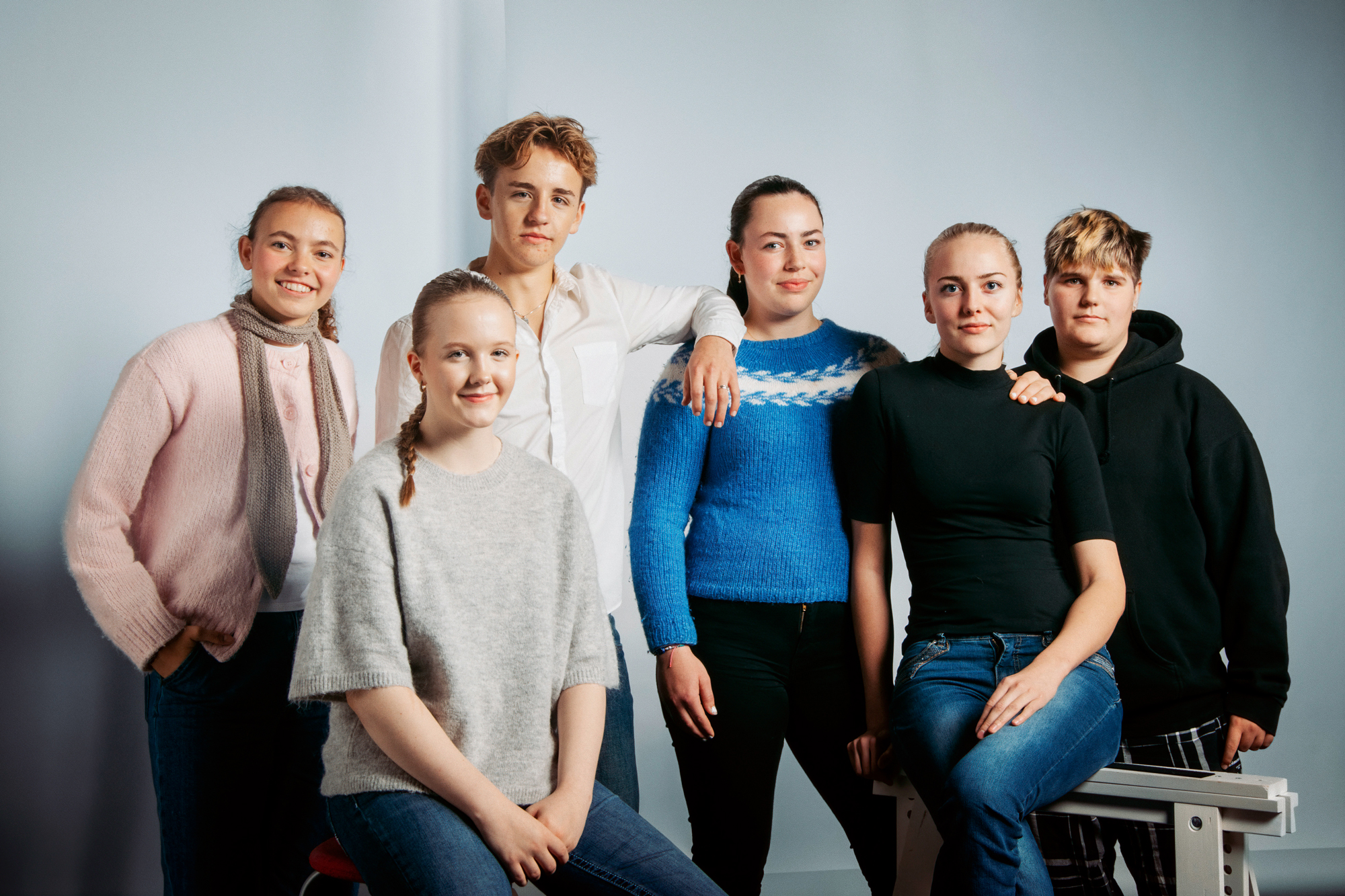 Seks elever ser i kamera. Inne.