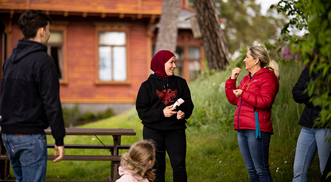 En ung kvinne og en eldre dame som snakker med hverandre og ler.