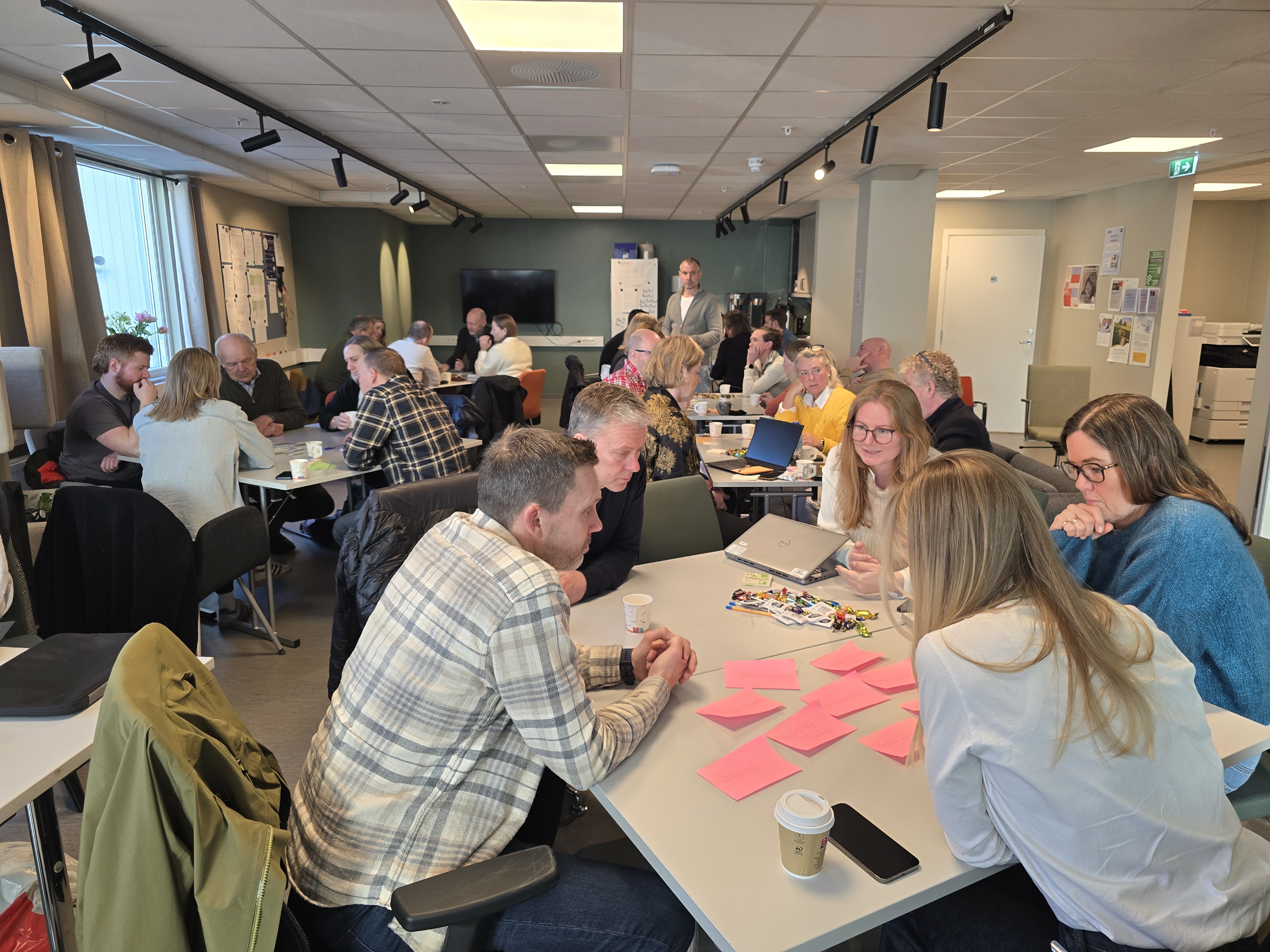 Oversikt over deltakerne som jobber med oppgaver på ulike bord.