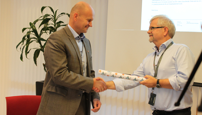 Statens vegvesens Tore Kaurin overleverer en symbolsk stafettpinne til fylkesordfører Rune Hogsnes