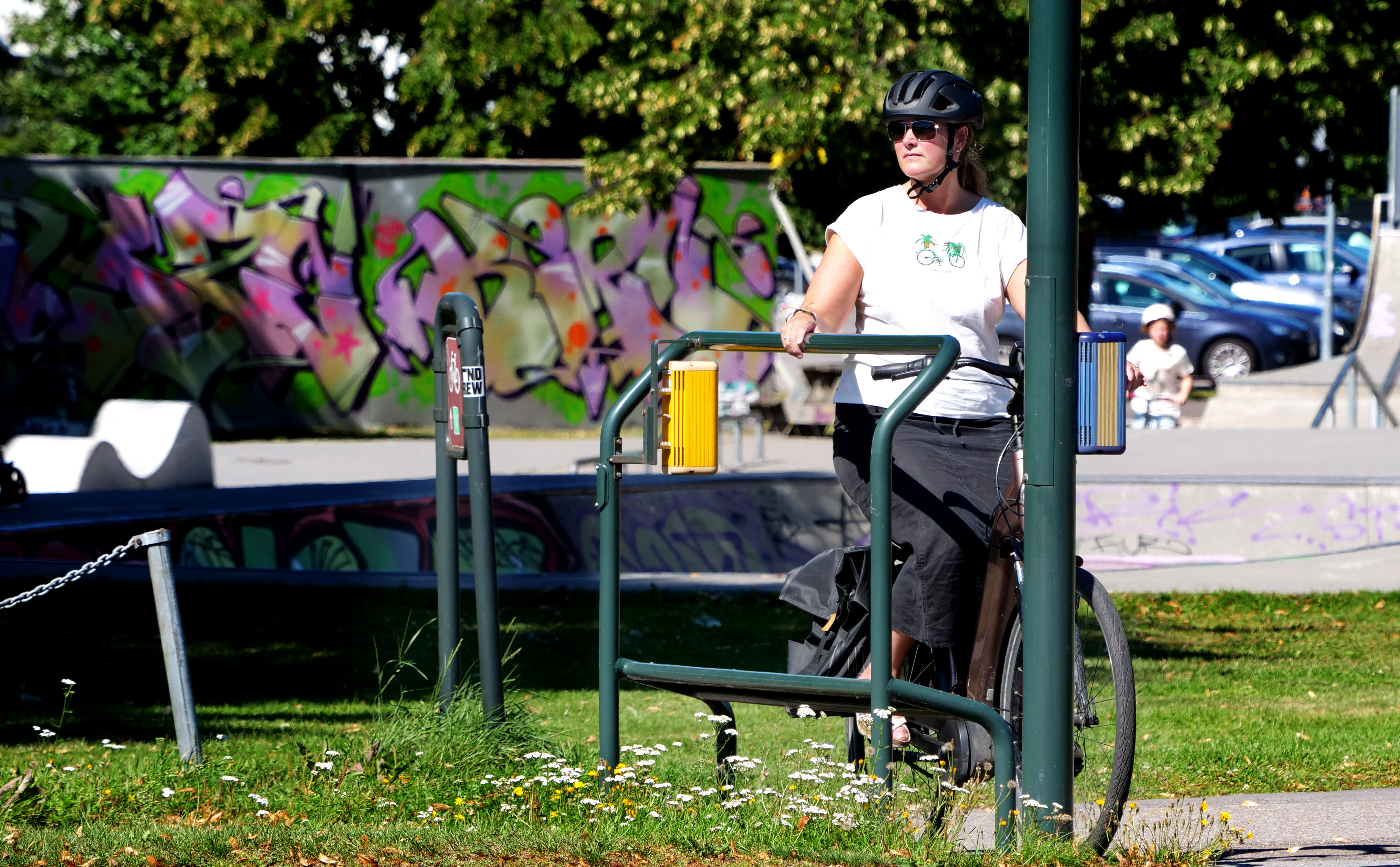 Kvinne på sykkel som bruker fothviler med stoppknapp ved lysovergang.