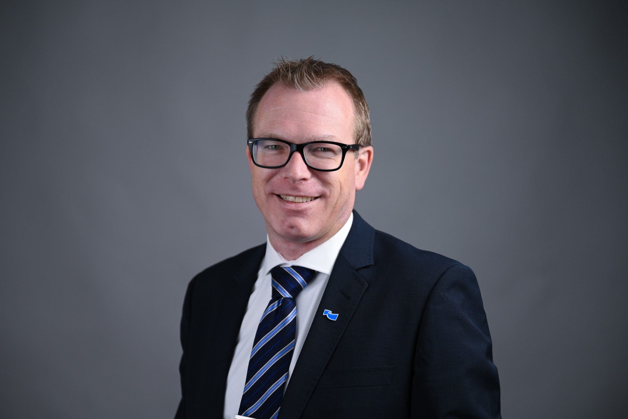 Portrett av mann med grå bakgrunn. Foto: Anders Palmer Holmen