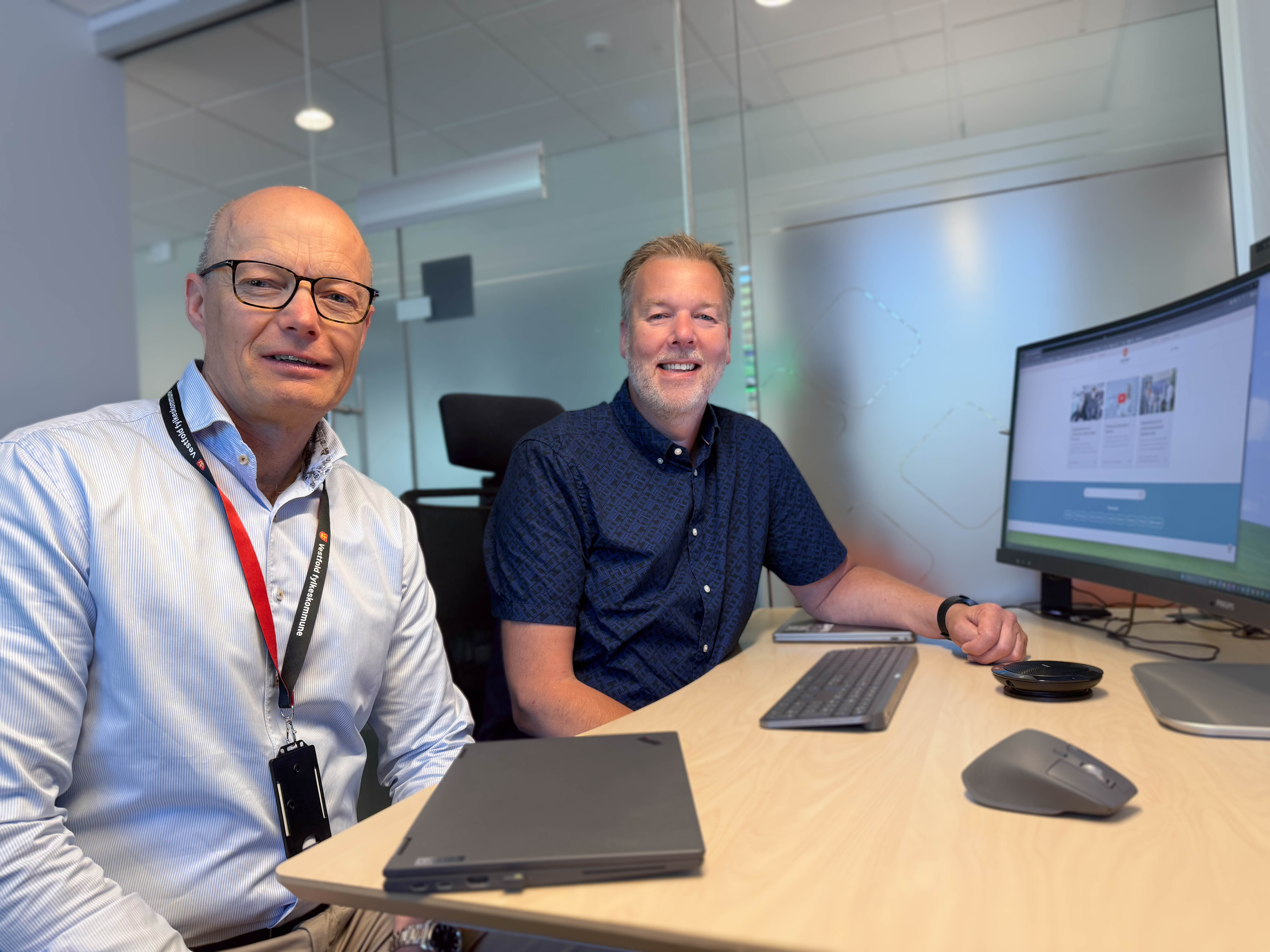 To personer sitter foran en datamaskin