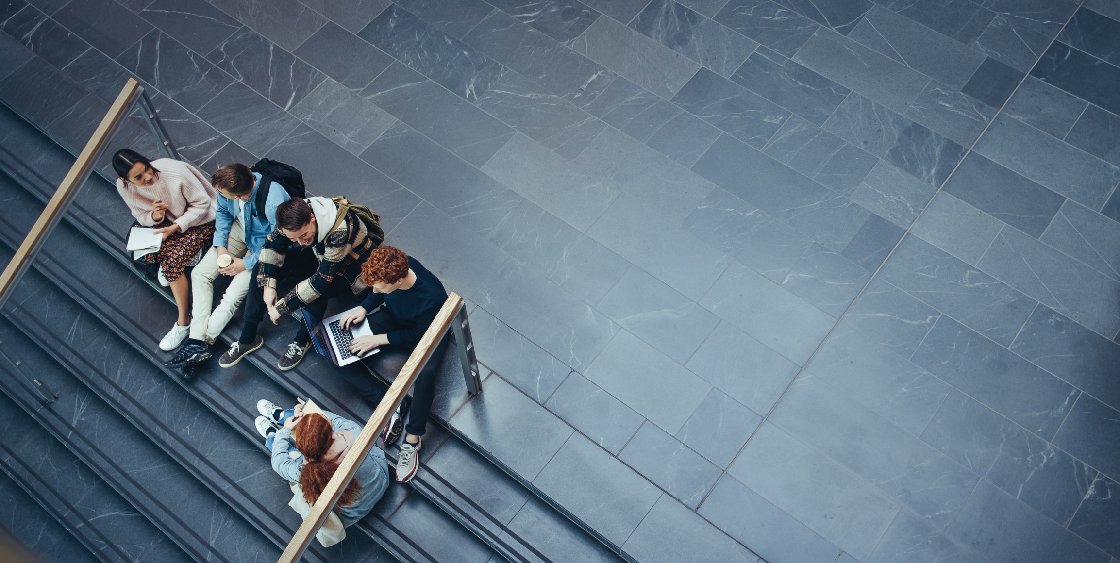 Unge som sitter sammen og snakker på en trappe