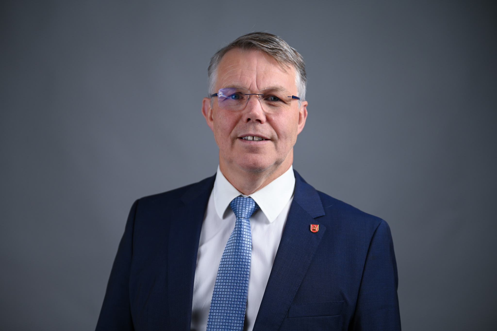 Portrett av mann med grå bakgrunn. Foto: Anders Palmer Holmen