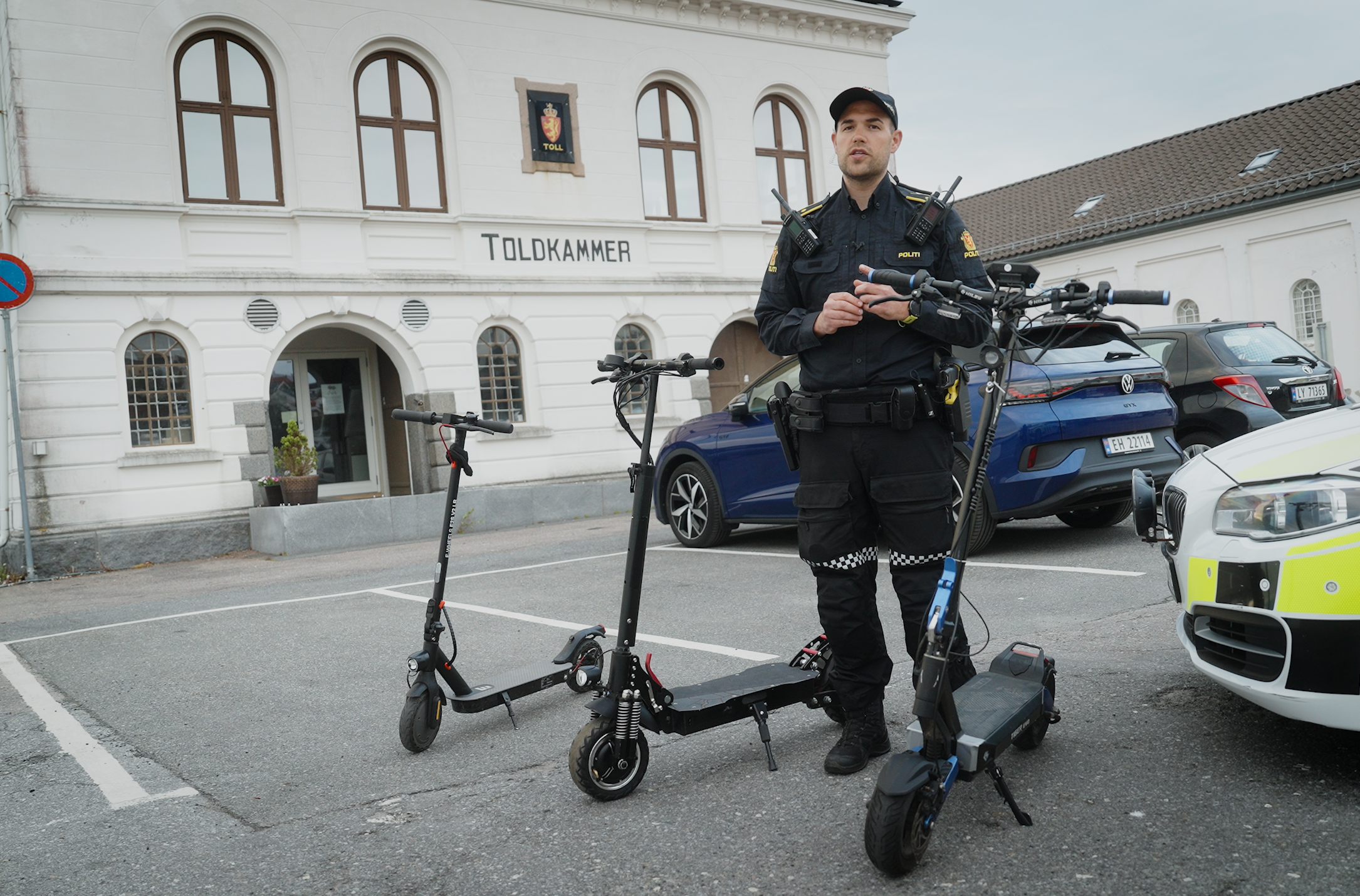Adrian hegge med tre elektriske sparkesykler foran en politibil