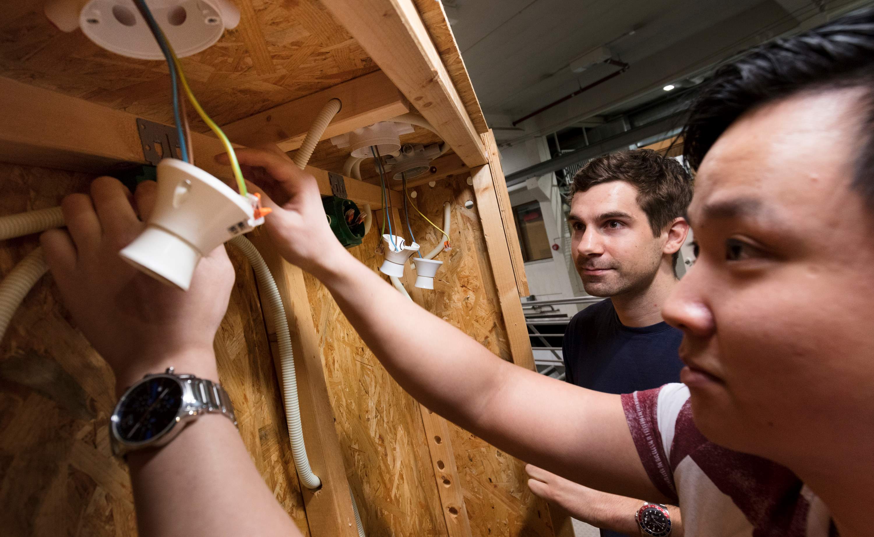 Bilde av to menn som kobler elektriske ledninger.