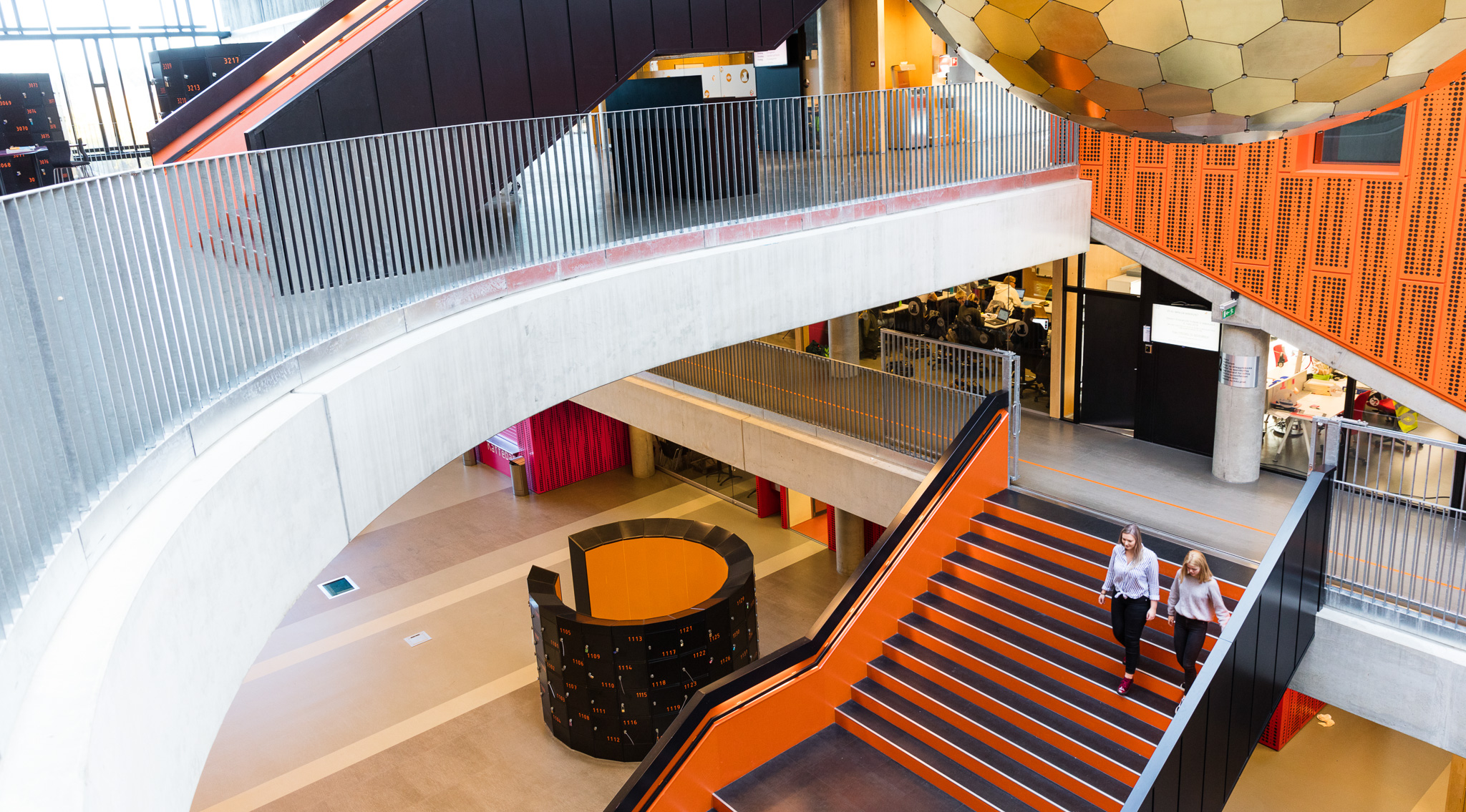 Bilde av elever som går ned oransje trapper på videregående skole