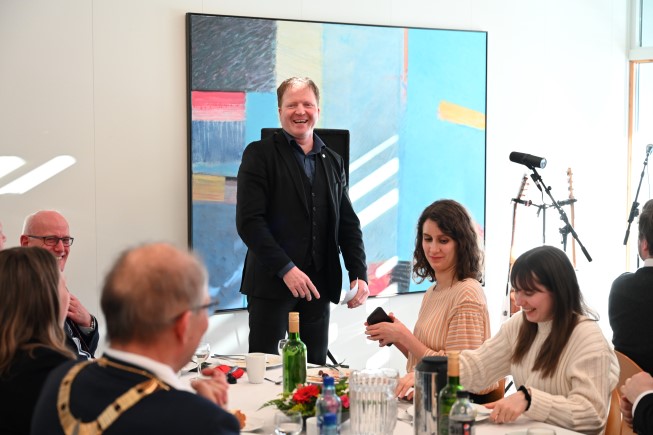 Sigbjørn Gjelsvik (Sp) er kommunal- og distriktsminister, og på bilde står han smilande og uttrykker glede over at arbeidsplassar er flytta ut i distriktet, til Seljord.