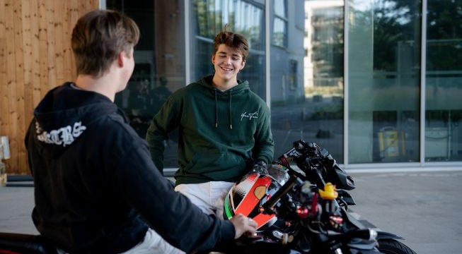 To gutter sitter på motorsykkel og snakker sammen