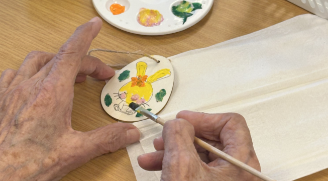 Eldre hender som maler påskepynt