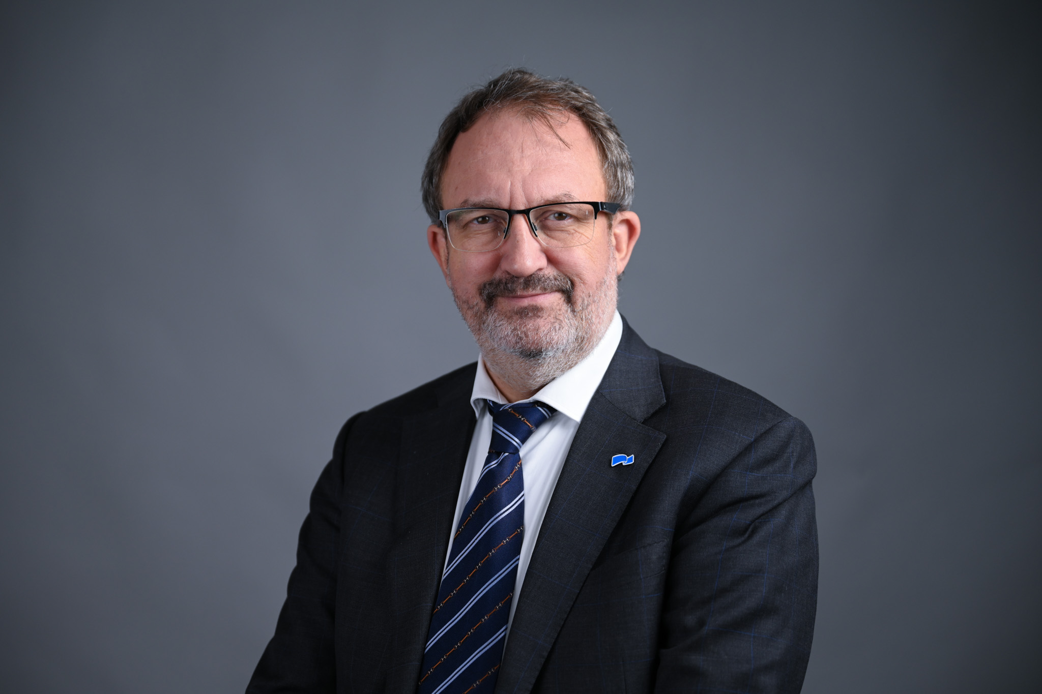 Portrett av mann med grå bakgrunn. Foto: Anders Palmer Holmen