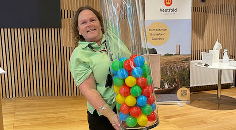 Dame med stor glassøyle med fargerike baller