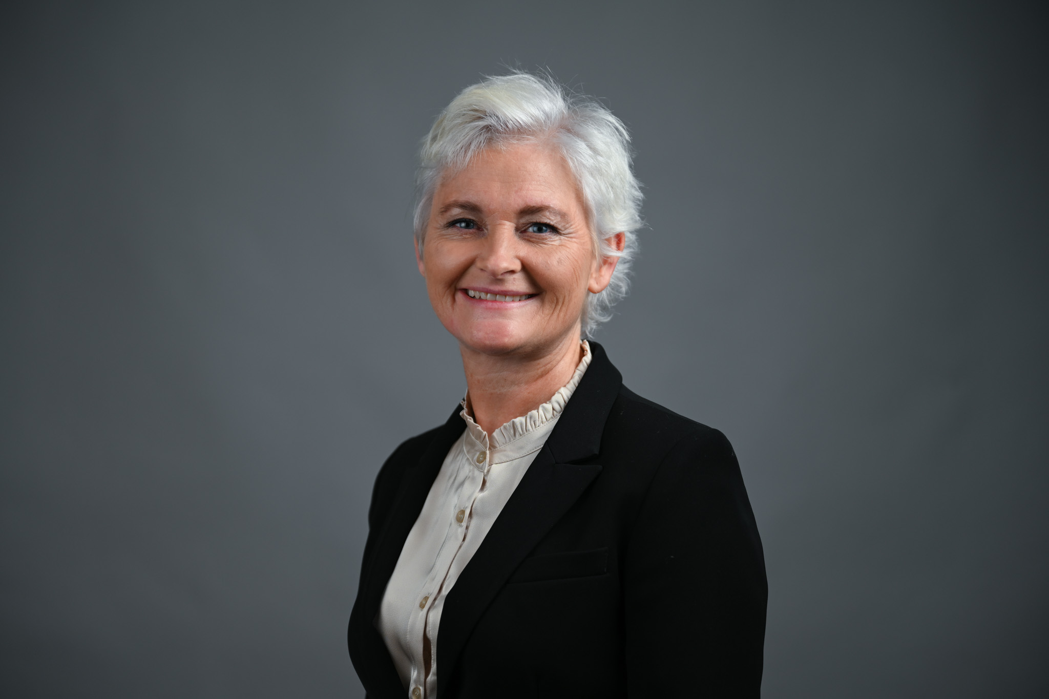 Portrett av dame med grå bakgrunn. Foto: Anders Palmer Holmen