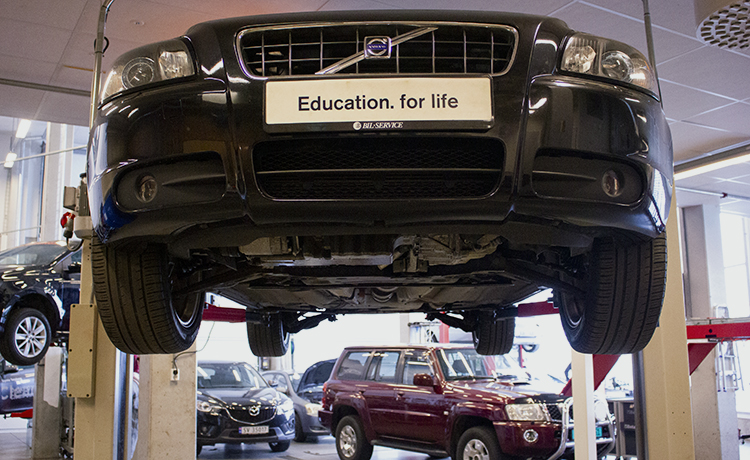 Bil på løftebukk i et verksted.