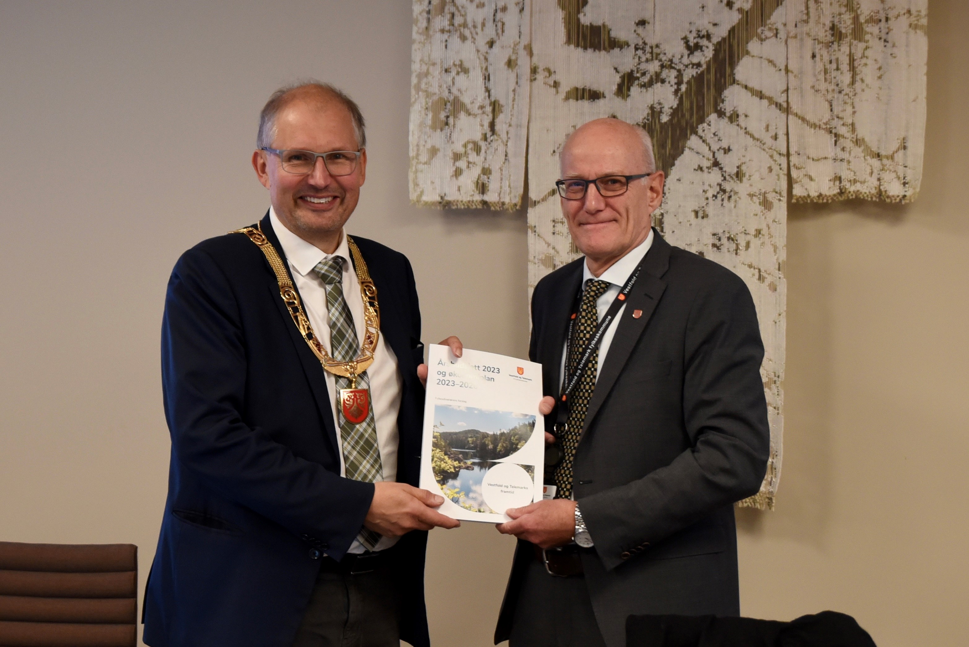 Fylkesordfører og fylkesdirektør med utskrift av budsjettforslaget