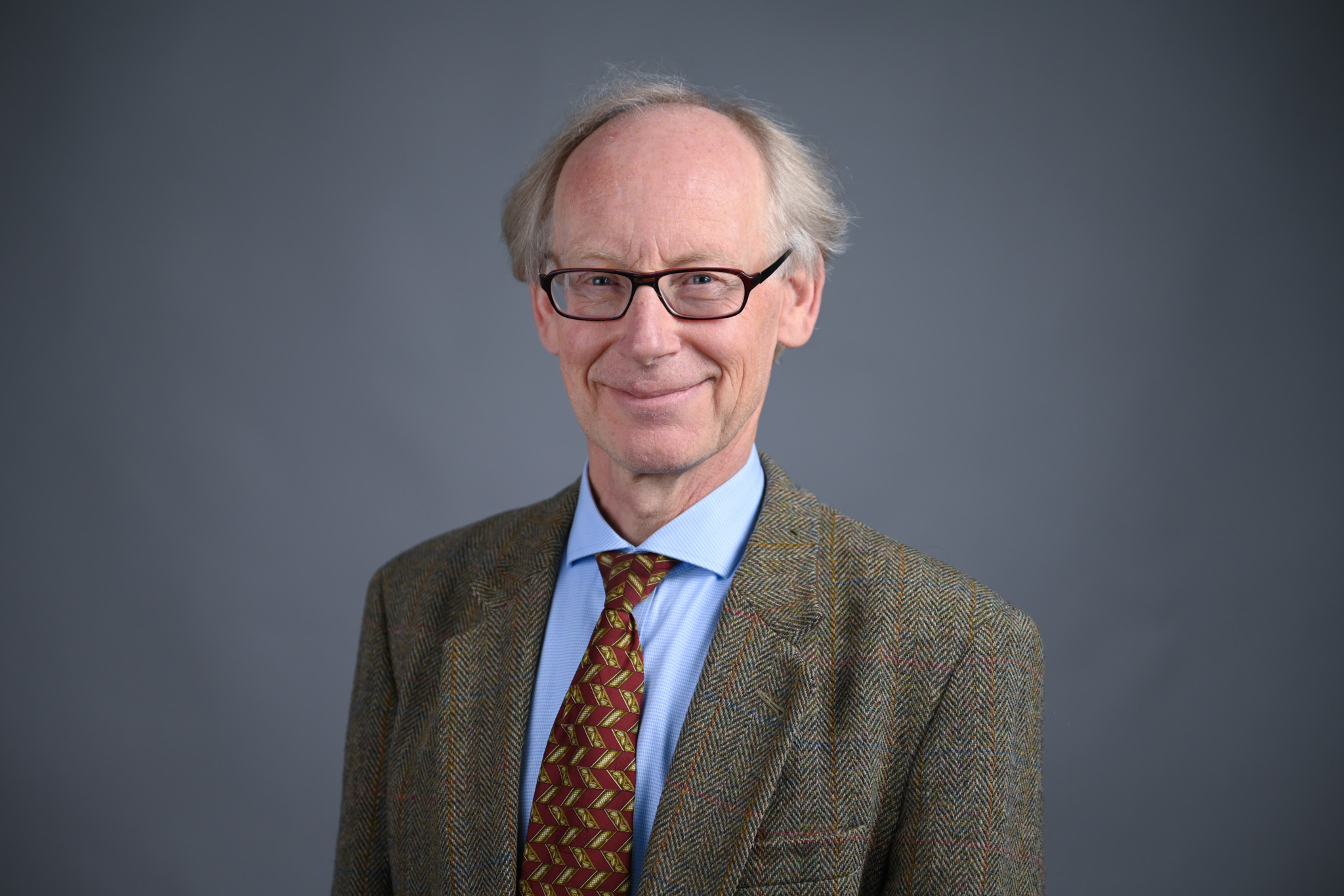 Portrett av mann med grå bakgrunn. Foto: Anders Palmer Holmen